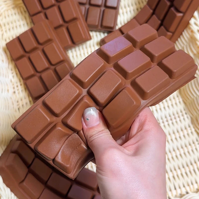 Hand drückt Schoko Tafel Squish – Slow Rise zusammen